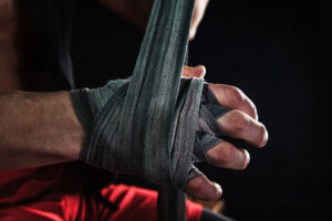 close-up-hand-with-bandage-muscular-man-training-kickboxing-black