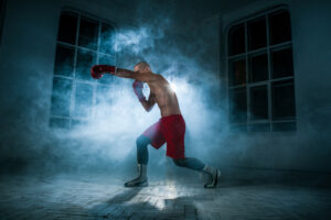 young-male-athlete-kickboxing-blue-smoke